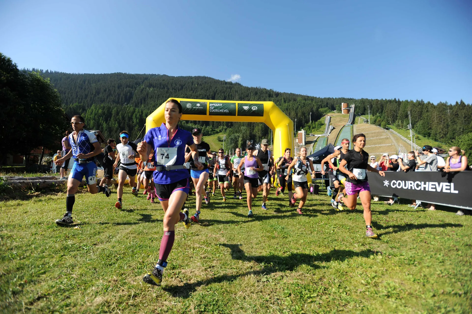 Coureurs au départ d’un trail d’été, arche en fond